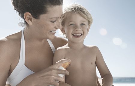 Майка нанася слънцезащитен продукт