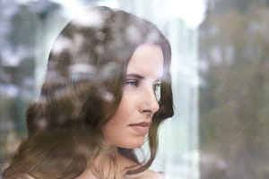 Жена, която гледа през прозореца