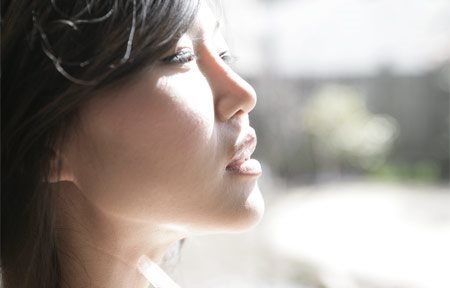 Азиатка, гледаща към слънцето. 