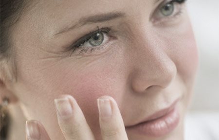 Жена докосва лицето си с ръка