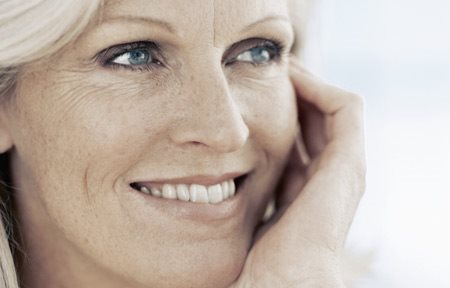 Жена на средна възраст се усмихва.